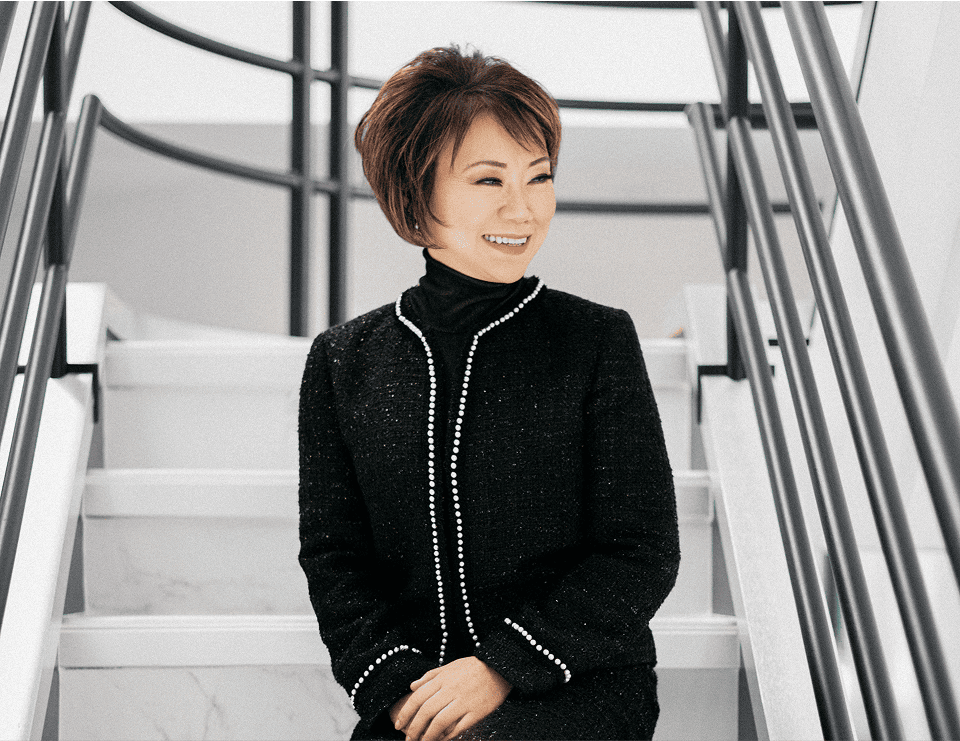 Maggie Chen standing on modern stairs in professional attire